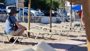 Strandbedden en parasolverhuurder wacht op klanten op Rhodos